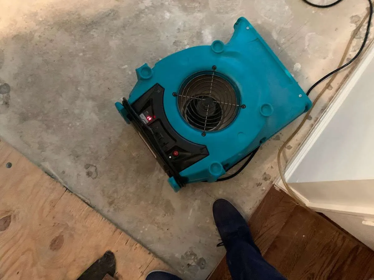 Air mover drying subfloor during Commercial Water Damage Restoration in Fort Morgan